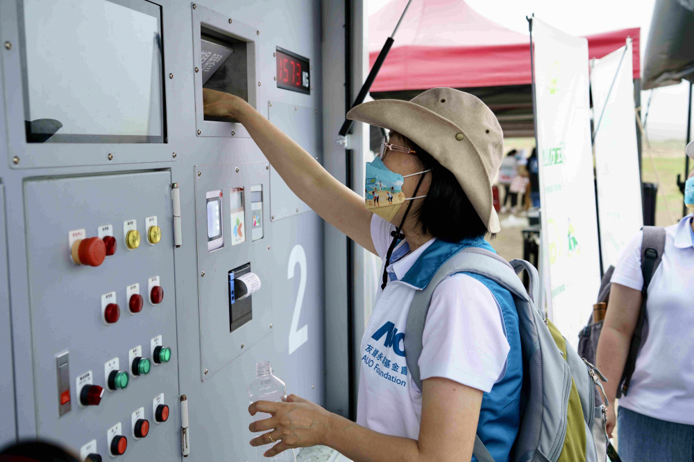志工們將拾起的寶特瓶投入「好歸塑專車」，讓廢棄塑料空瓶可以直接粉碎、縮小體積，未來將可再製成購物袋、寶特衣、悠遊卡等生活用品